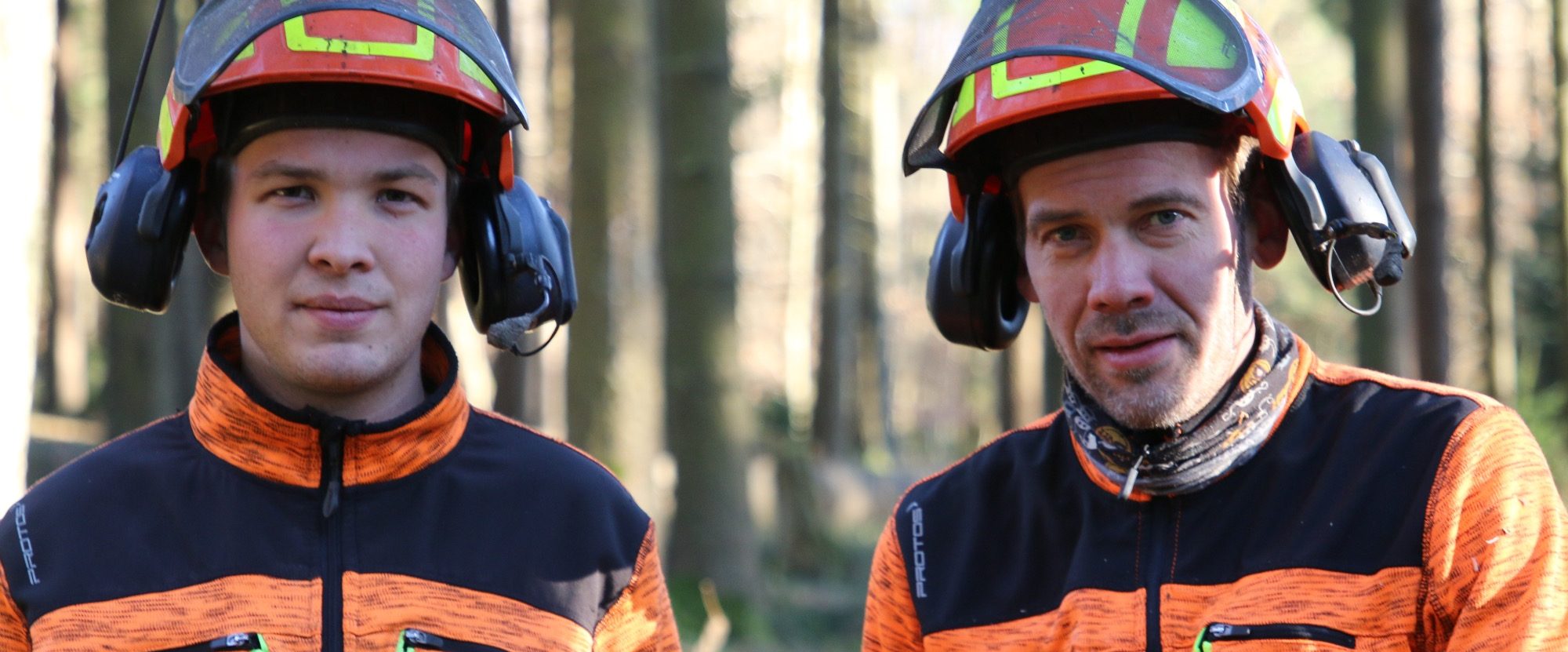 Philipp Bitsch (links im Bild) und Jochen Bitsch (rechts im Bild) in Arbeitskleidung im Wald.